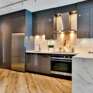 Modern modular kitchen with grey cabinets, a marble-look counter and wood-look flooring