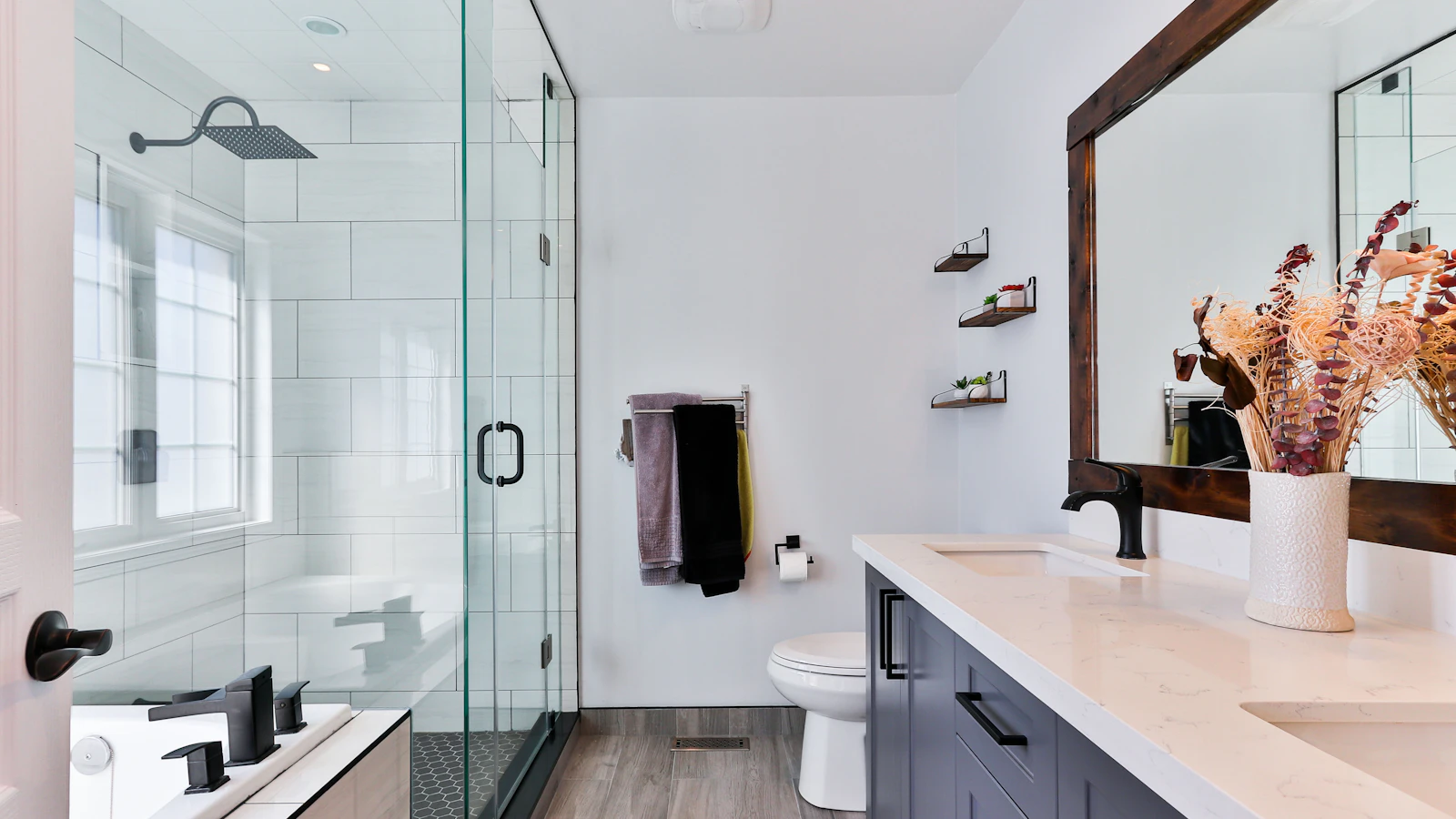 Bathroom with a glass shower enclosure, wall-mounted fittings and a vanity with a large mirror
